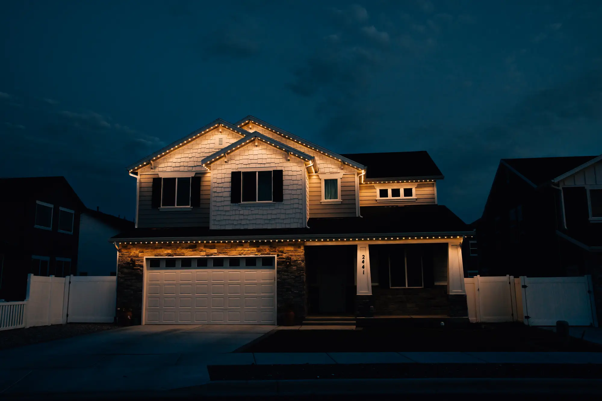 Draper, Utah home with CHIPR LUX permanent roofline lighting glowing warm white at dusk