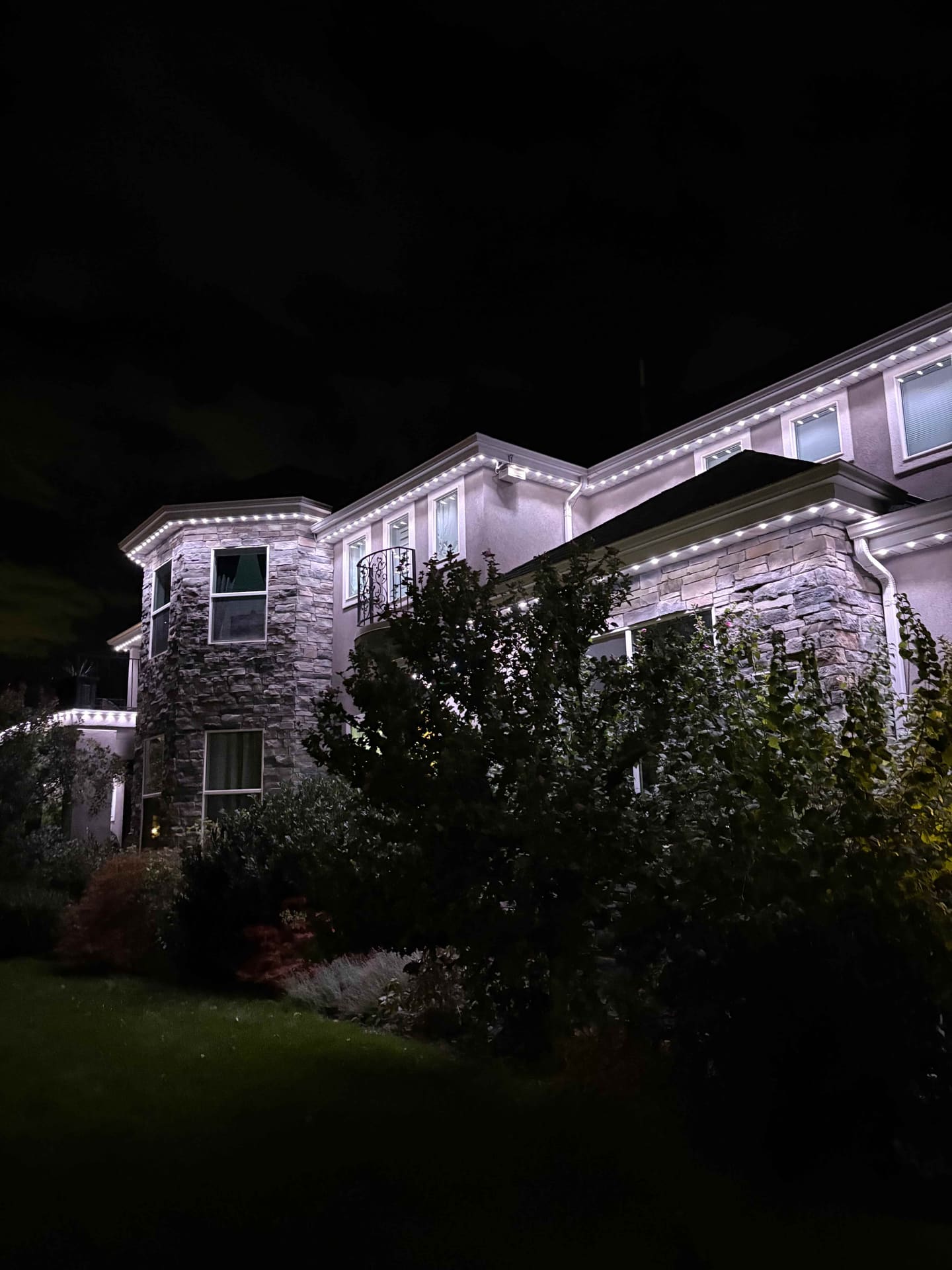 Stone and stucco home with clean white roofline lighting